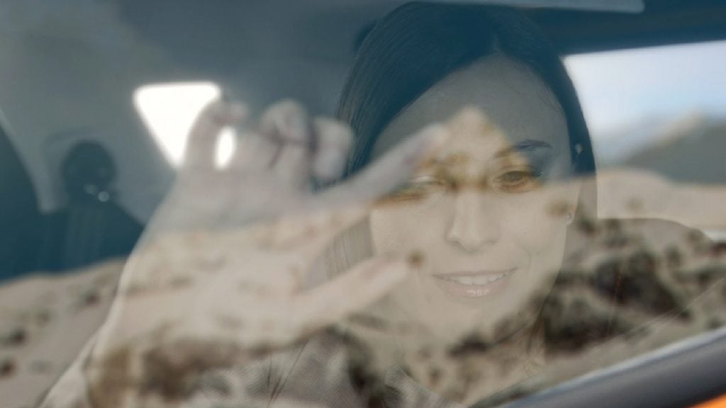 A vak hölgy kitapogatja a hegylánc alakját az autó ablakában (forrás: Ford)
