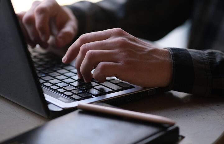 laptopon gépelő ember
